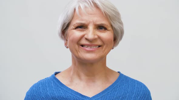 Portrait of Smiling Senior Woman Over Grey 1 alt