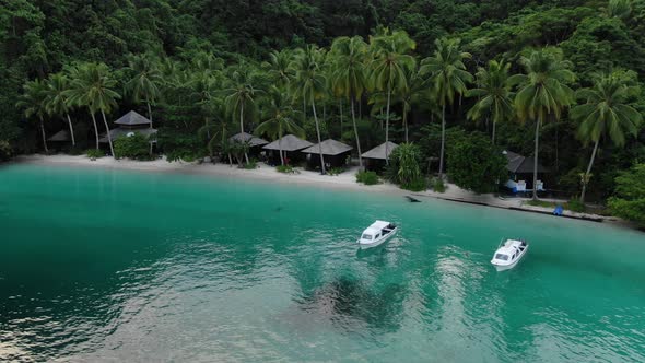 Boats Near Ocean Beach With Huts Among Palm Trees In Triton Bay, Raja Ampat.  alt