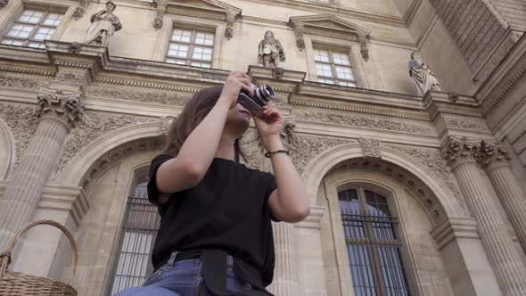Beautiful Young Woman with Dark Hair Wearing Jeans and Black Tshirt Is Taking Pictures of the City