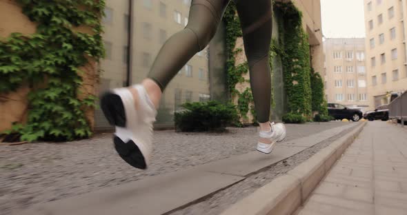 Woman Running in a City Street Legs Closeup Slow Motion alt