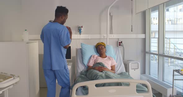 African Male Physician Examining Female Patient with Stethoscope in Hospital Room alt