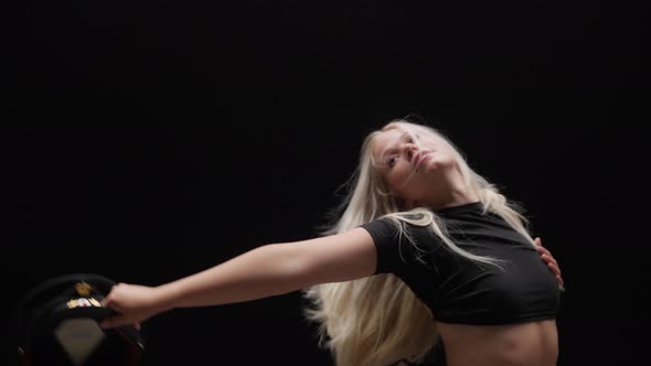 Alluring Young Woman Dancing in Studio Against Black Background alt