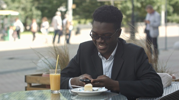 Handsome young afro american businessman using smart phone