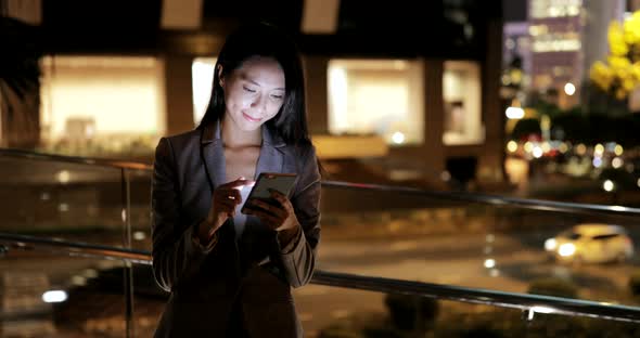 Business woman working on mobile phone at night 
