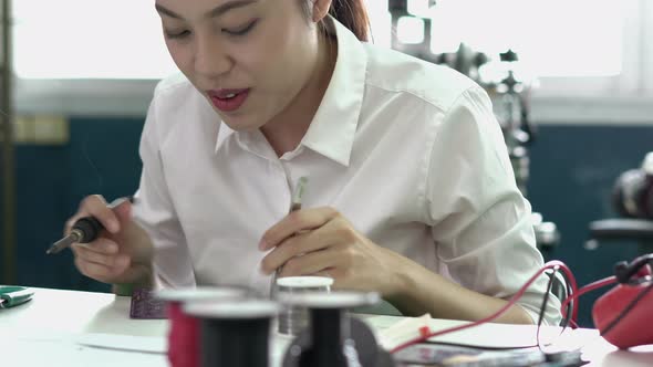 Student woman are assembling and testing electric circuit alt