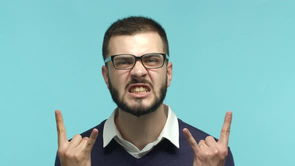 Close Up of Caucasian Bearded Man in Glasses and Office Shirt Showing Rocknroll Gesture Horns and