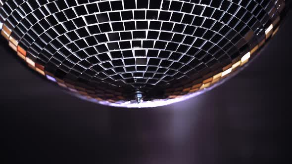 Party lights disco ball. Silver disco ball hanging on the wall alt