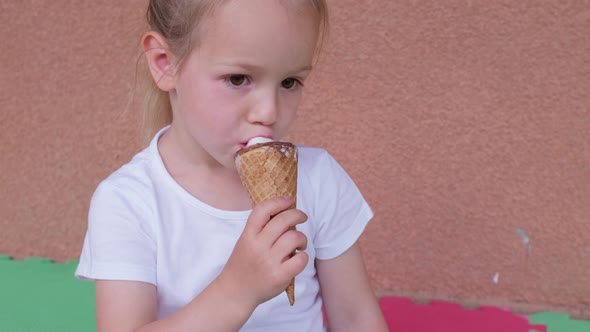 Little Girl Eating Ice Cream in a Cone Summer Family Lifestyle at Home alt