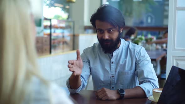 Closeup View From Back of Two Male and Female Business Partners Shaking Hands Over Coffee in Coffee alt