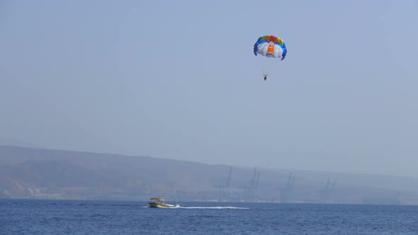 Motor Boat Tows a Special Parachute Over the Sea alt