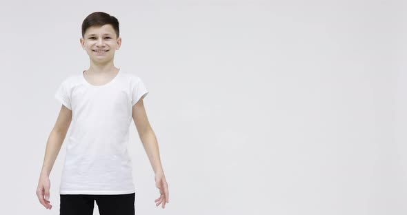 Young man 15s in white t-shirt dancing fooling around having fun expressive gesticulating hands