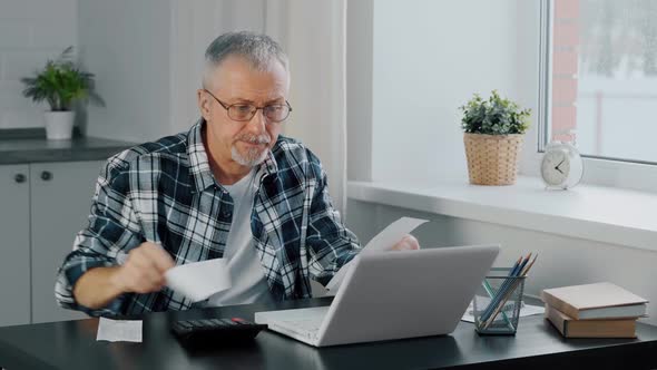 An Unhappy Elderly Man Gets Upset While Counting Household Expenses