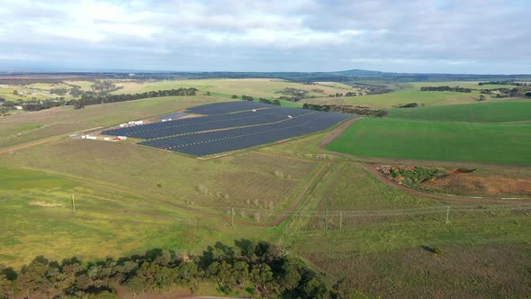 AERIAL Large Solar Farm Located On Green Fields On Sunny Day alt
