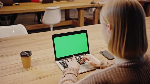 Over Shoulder View of Female Student Typing on Laptop with Green Chroma Key Screen Studying at alt