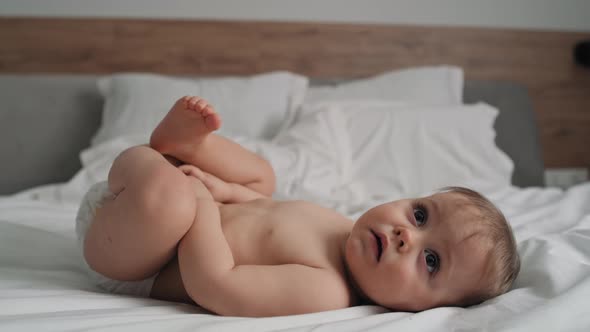 Video of cute little girl after the bath lying on the bed. Shot with RED helium camera in 8K. alt