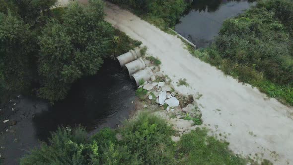Flying over concrete sewers. Streams of water flow through concrete pipes. alt