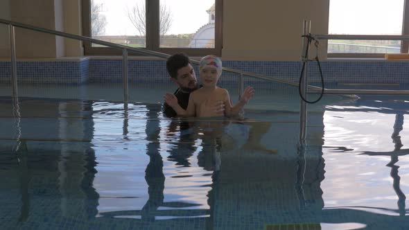 Therapist and child doing gymnastics in pool alt