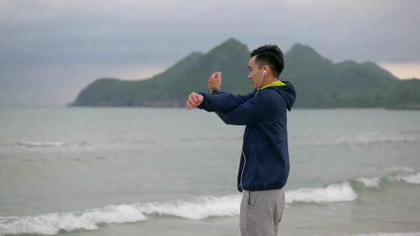 Handsome man running on the beach, Sportsman stretching before running along the beach.