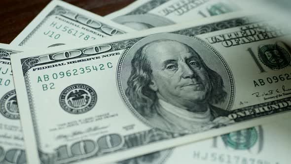 Hundred Dollar Bills Fall on Brown Table