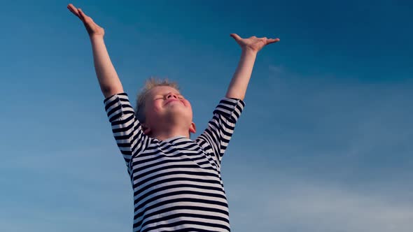 Relaxed Boy Breathing Fresh Air Raising Arms Over Blue Sky at Summer alt