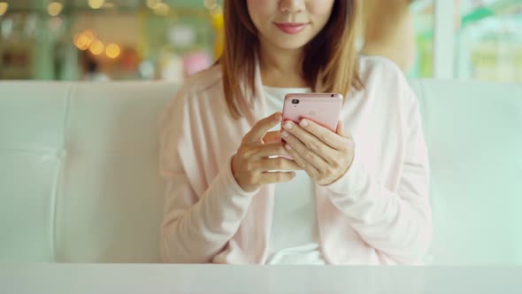 Smile happy young asian woman relaxing and using smart phone in the morning at home