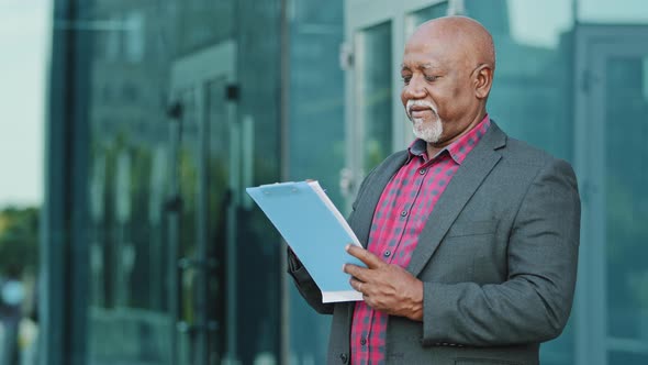 Elderly Serious Concentrated Businessman Architect or Artist Standing Outdoors Holding Paper alt