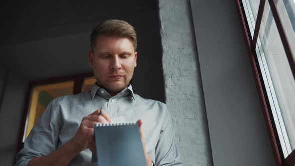 Young businessman with a notepad alt