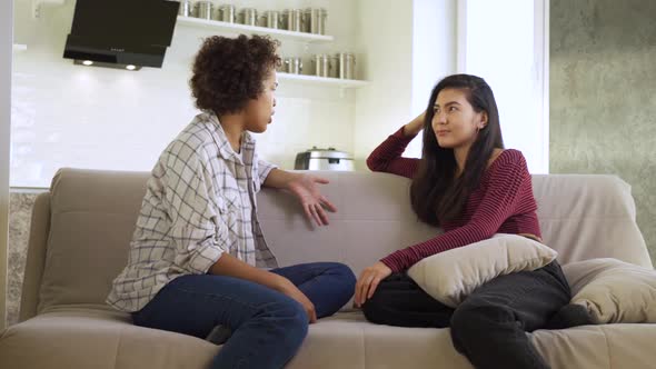 Slow Motion Two Girlfriends an AfricanAmerican and an Asian Chatting with Each Other While Sitting alt