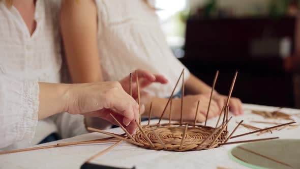 Smiling Woman Teaching Paper Vine Basket to Daughter at Home