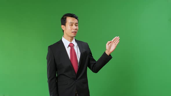 Asian Businessman Pointing On Something And Talking On A Green Screen, Chroma Key alt