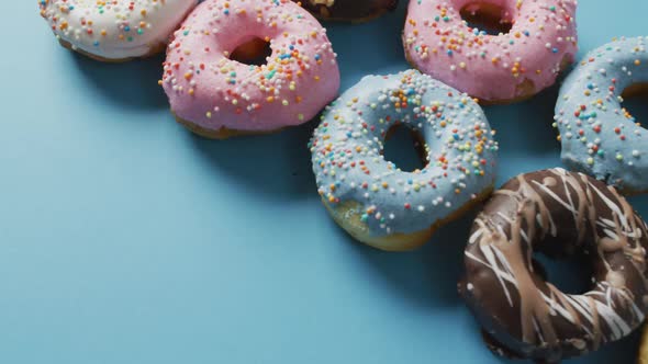 Video of donuts with icing on blue and purple background alt