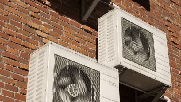 Multiple outdoor air-conditioner units on the brick wall during the day. 4K HD