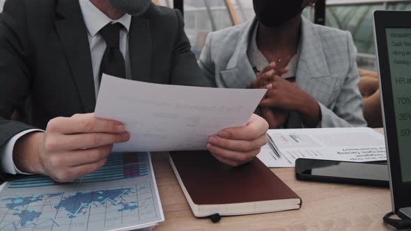 Cropped Colleagues in Masks at Table alt