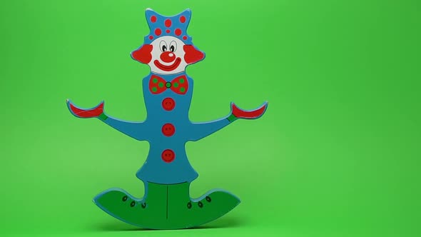 Funny wooden clown on green background