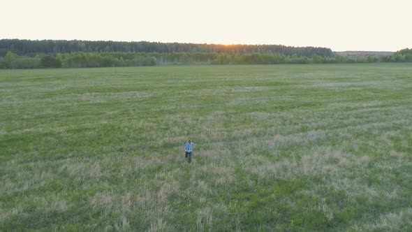 Happy Boy Is Running Down the Field on Sunset