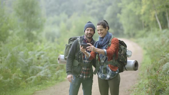 Couple talking self photograph in forest trail