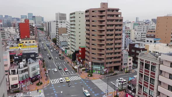 Tokyo city skyline and busy traffic on a cloudy grey day. Pan shot from high up. Gimbal. alt