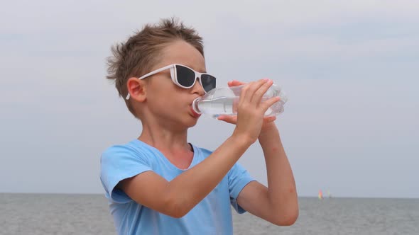 Cute Baby Drinking Drinking Water From a Bottle on a Hot Day alt