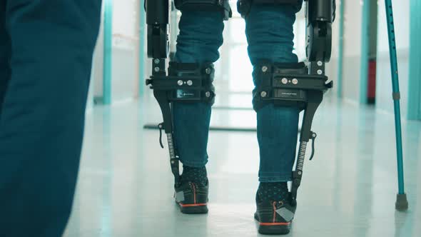A Person is Training to Walk in the Exoskeleton with Assistance alt