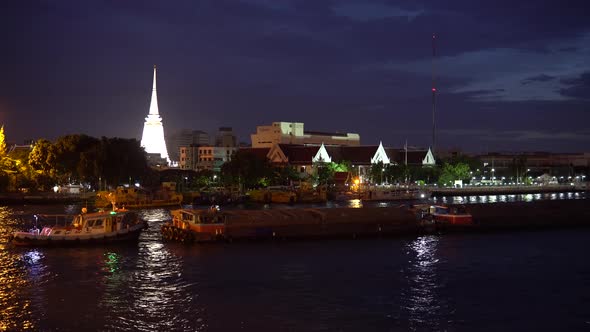 Cargo barge moving on river at night time in downtown