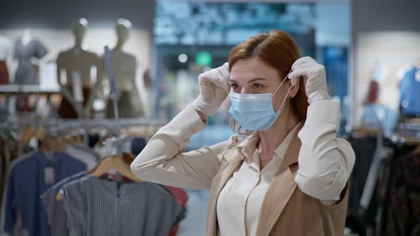 Purchase in Coronavirus, Happy Female Customer in Medical Gloves Putting on Face Mask To Protect alt