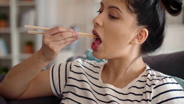 Tracking video of woman eating chopsticks Chinese food alt