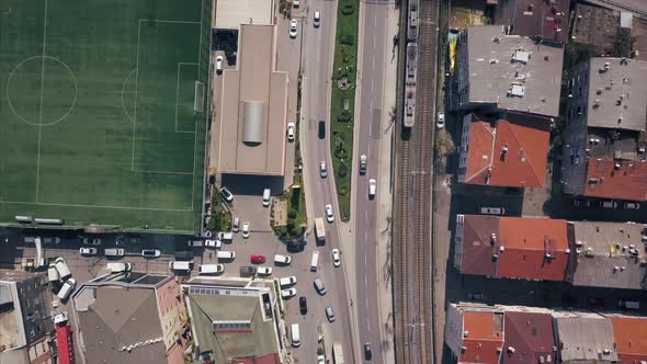 Aerial Top View Of Train Rail And Train Goes Next To Highway alt