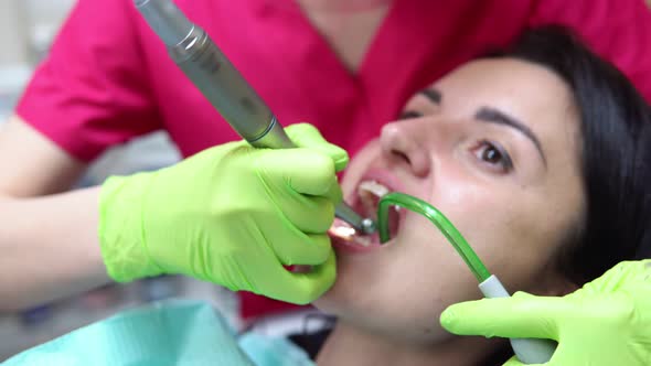 Dentist Cleans Woman's Teeth with Professional Toothpaste and Automatic Brush alt