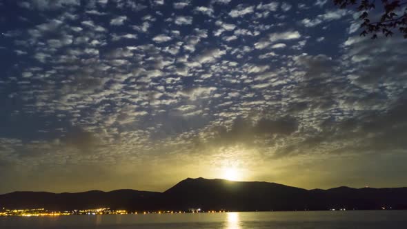 Time Lapse of moon rise over lake with golden colors alt