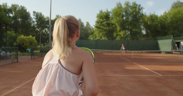 Slow Motion Shot of Female Tennis Players Practicing on Clay Court on Summer Sunny Day