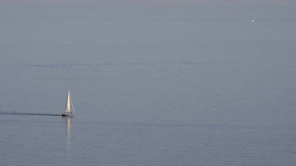 A Small Blue Yacht on the Sea Surface alt