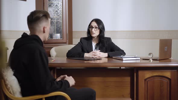 Portrait of Confident Professional Female Psychologist Talking To Depressed Man in Office alt