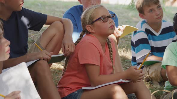 Kids at outdoor school have group lesson by pond