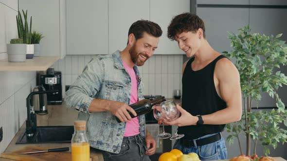 Gays Couple in Love Having Fun Drinking Wine Talking Preparing Meal in Kitchen at Home alt